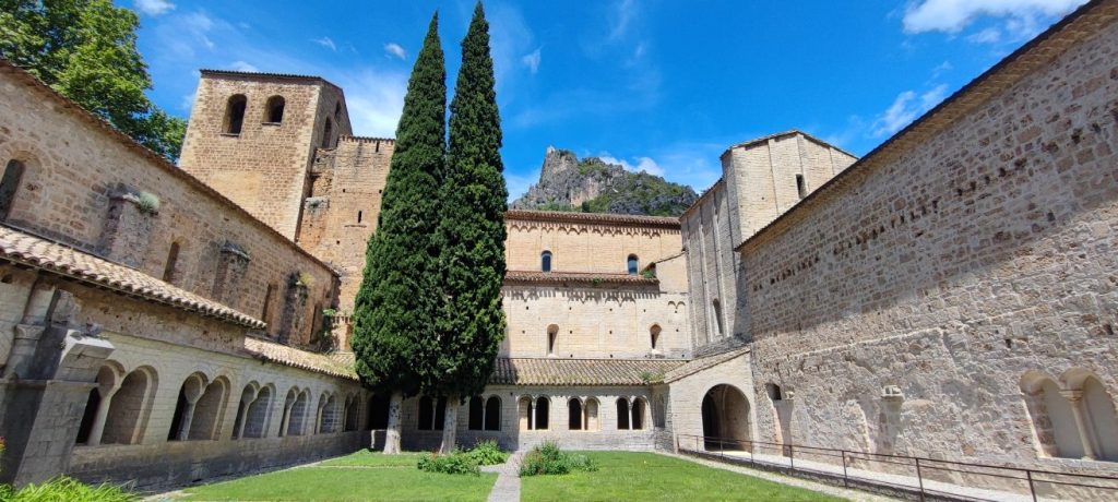 Photo du cloître de l'Abbaye de Gellone à Saint-Guilhem-le-Désert avec vue sur le château du Géant