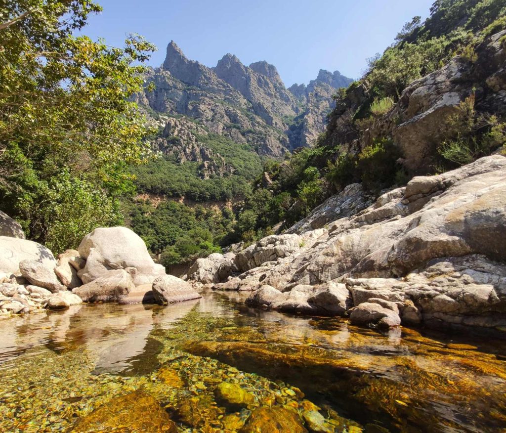 Photo des Gorges d'Héric et du ruisseau d'Héric. En arrière plan, les sommets du massif du Caroux et de l'Espinousse