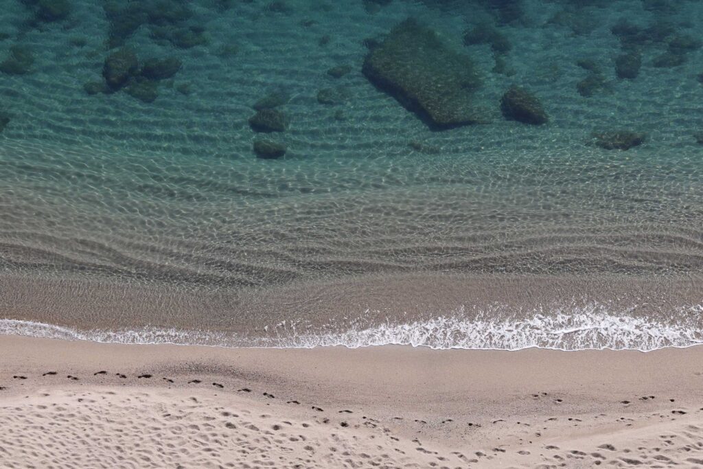 Photo de la Plagette de Leucate vue du sommet des falaises. De très belles couleurs entre le sable et la mer Méditerranée